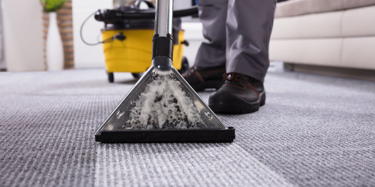 Person Cleaning Carpet With Vacuum Cleaner