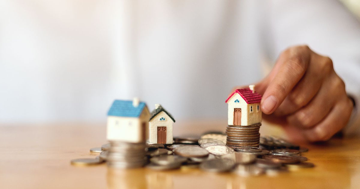 putting house model on pile of coins