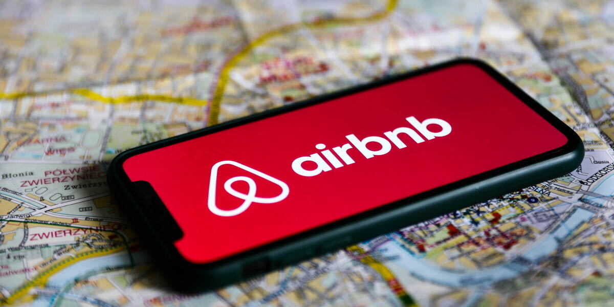 Airbnb logo on an Iphone screen placed on a map