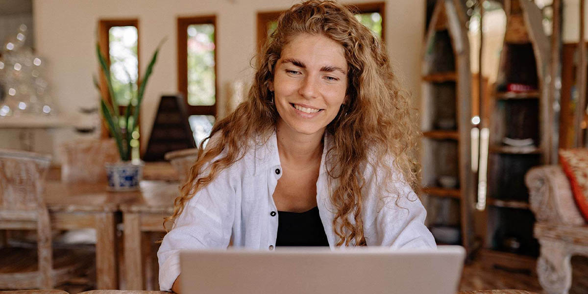 a smiling woman using her laptop