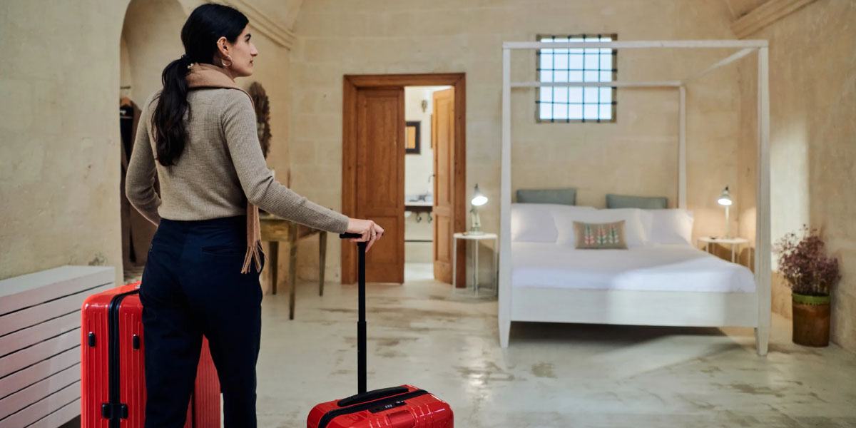 a woman entering an Airbnb with two luggages