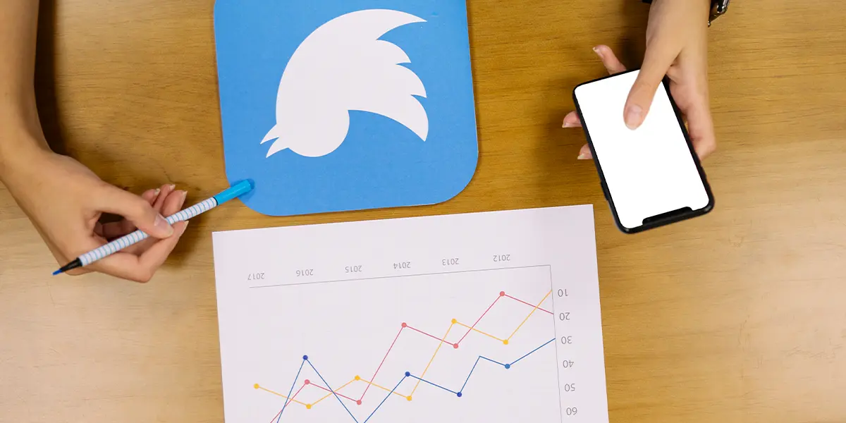 person holding a mobile phone analyzing the Twitter and Airbnb social media marketing graph